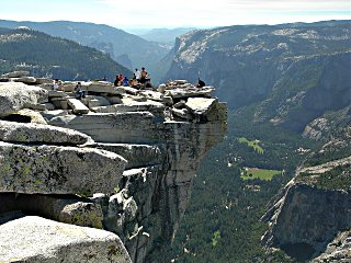 Hikers eating lunch on Half Dome's overhang